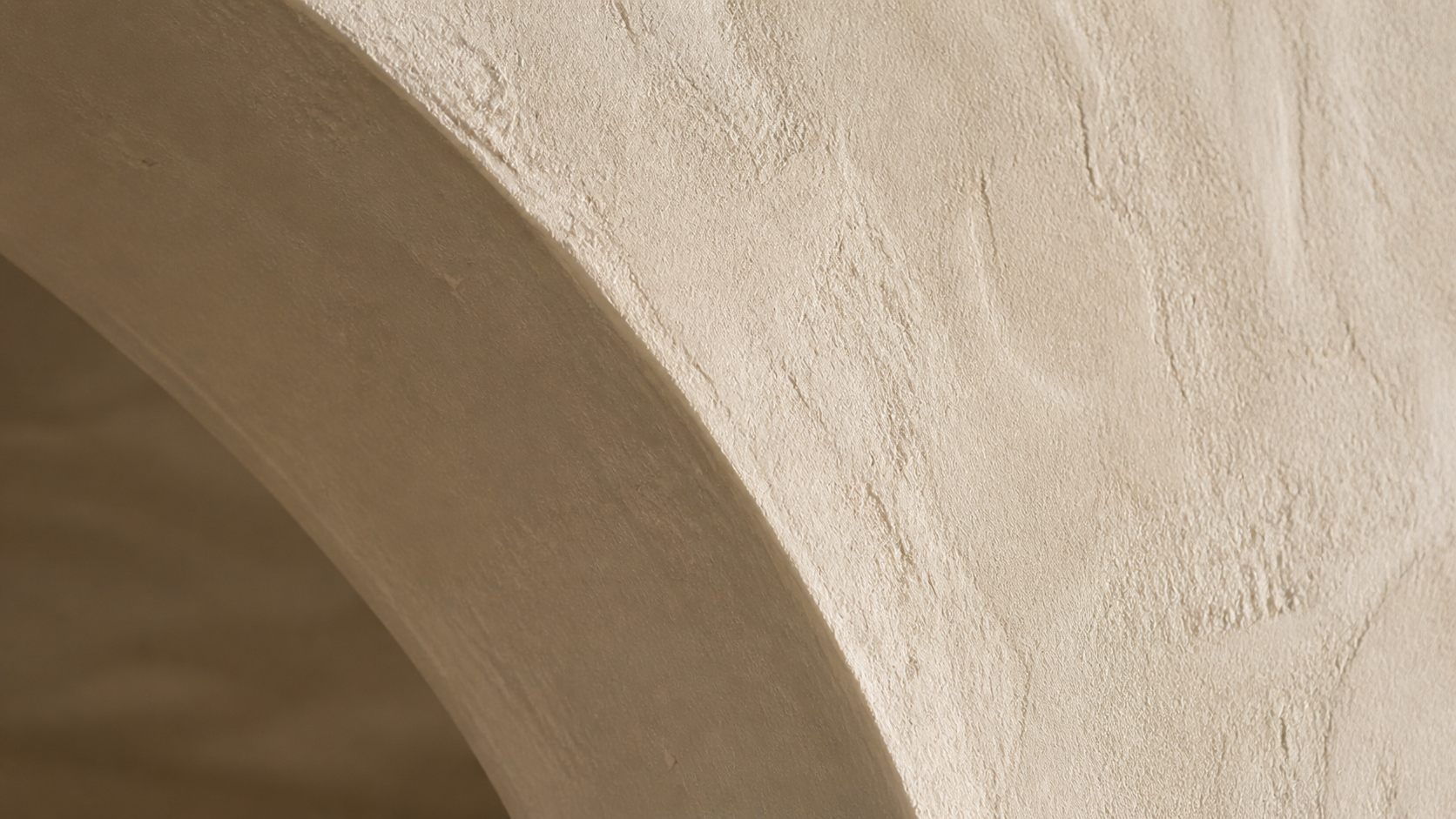 Close-up detail of a hand-troweled plaster arch springline