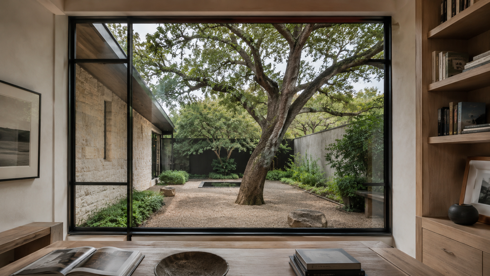 Study window framing a long view to a private courtyard with a live oak