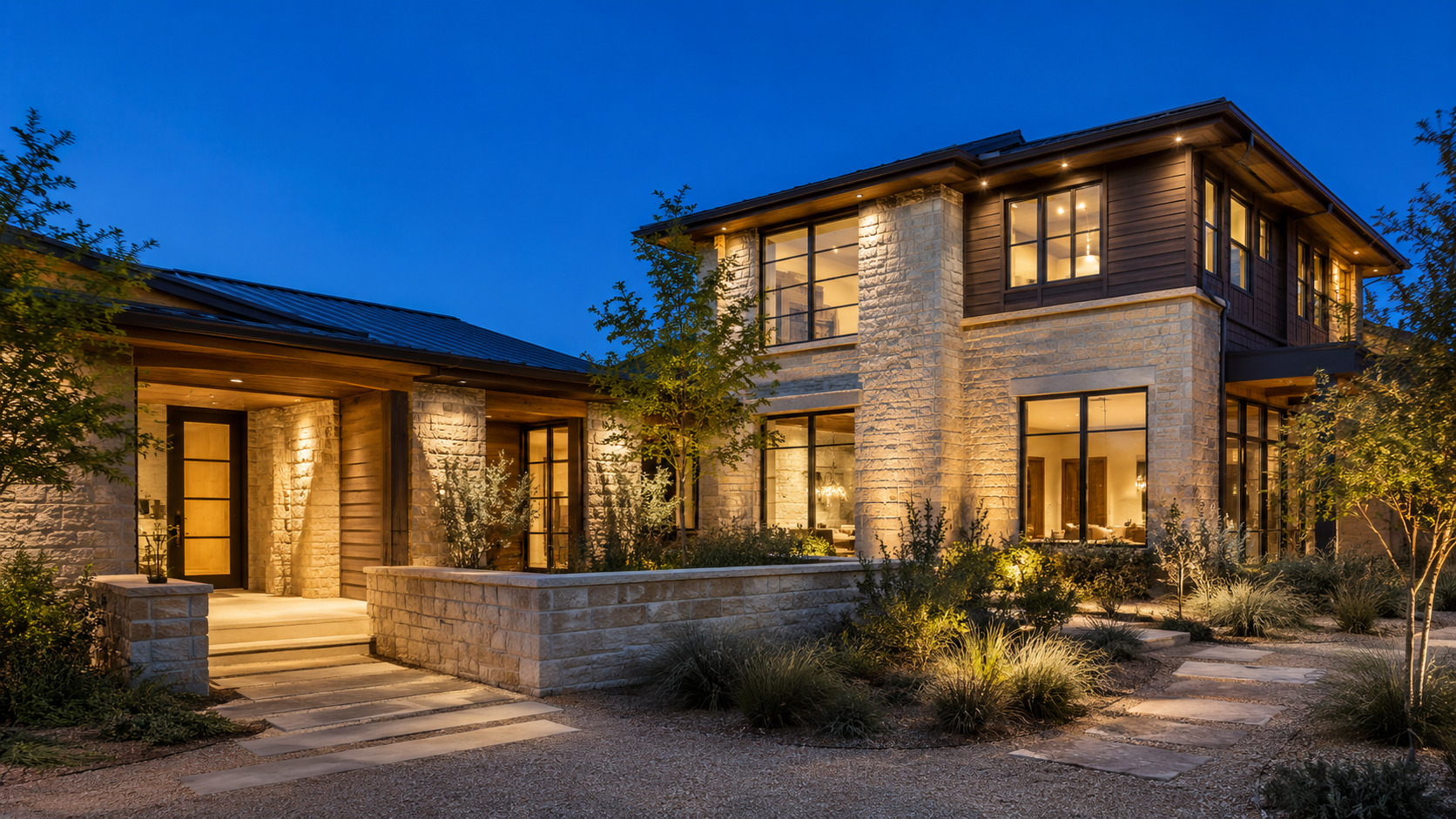 Custom home with an attached single-story guest wing and its own entry at dusk