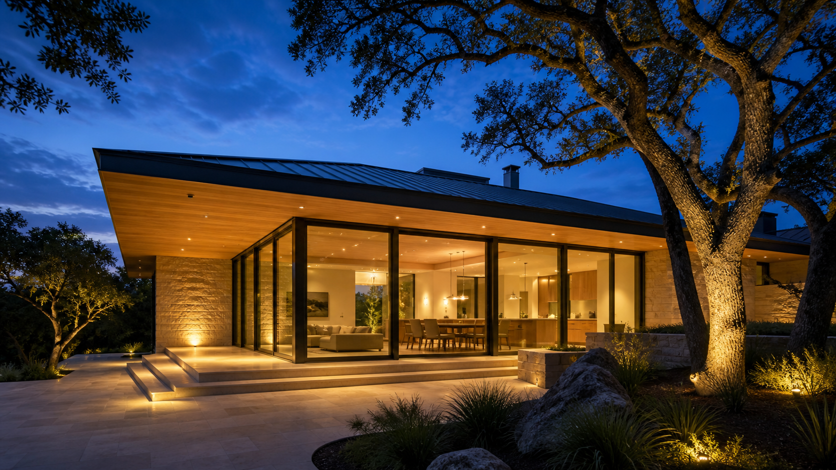 Modern Texas custom home at twilight with deep shaded overhang and layered exterior lighting